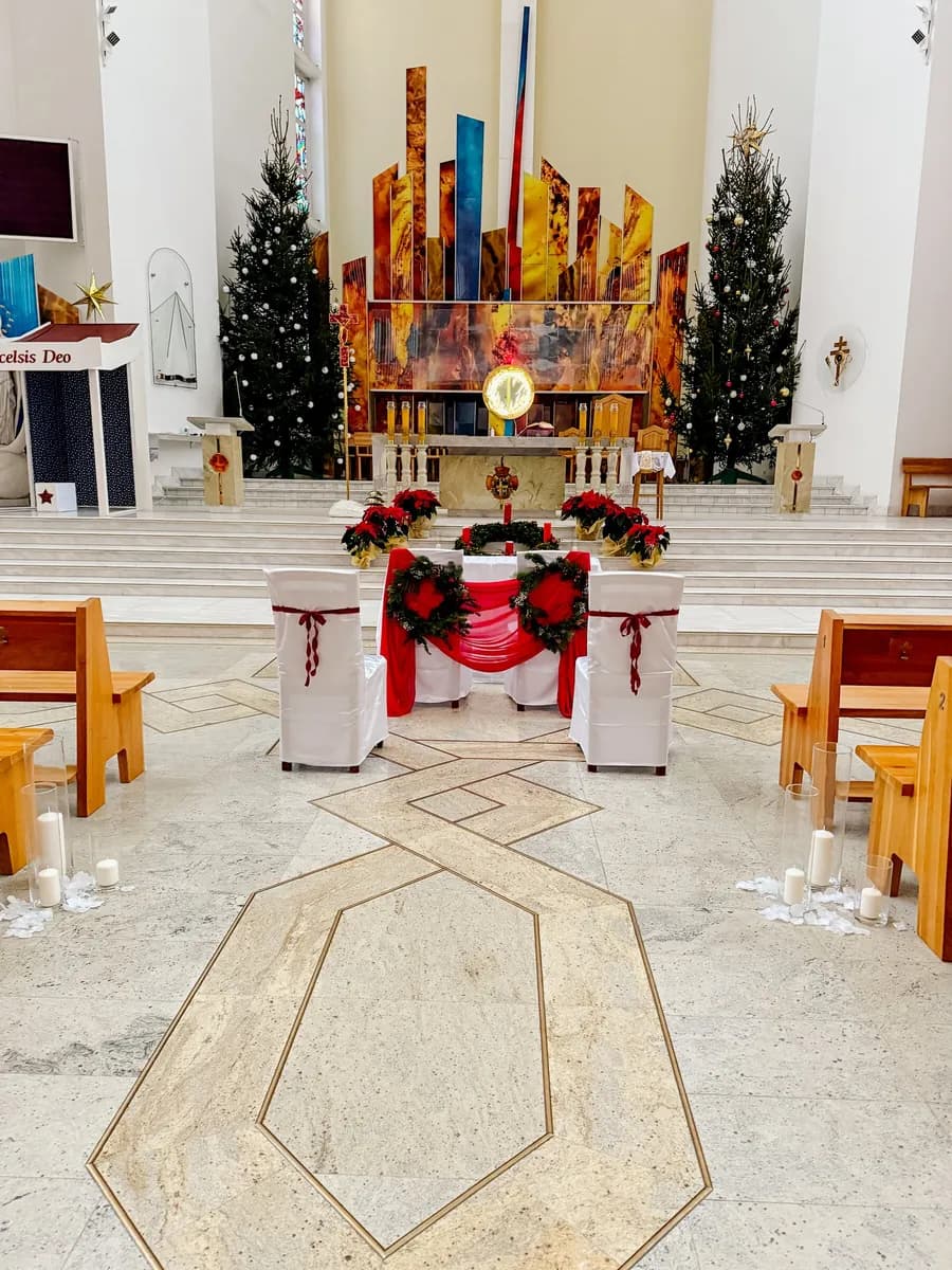 Altar in church decorated for a Christmas wedding - Christmas trees, stars of Bethlehem and chairs of the bride and groom with red draperies