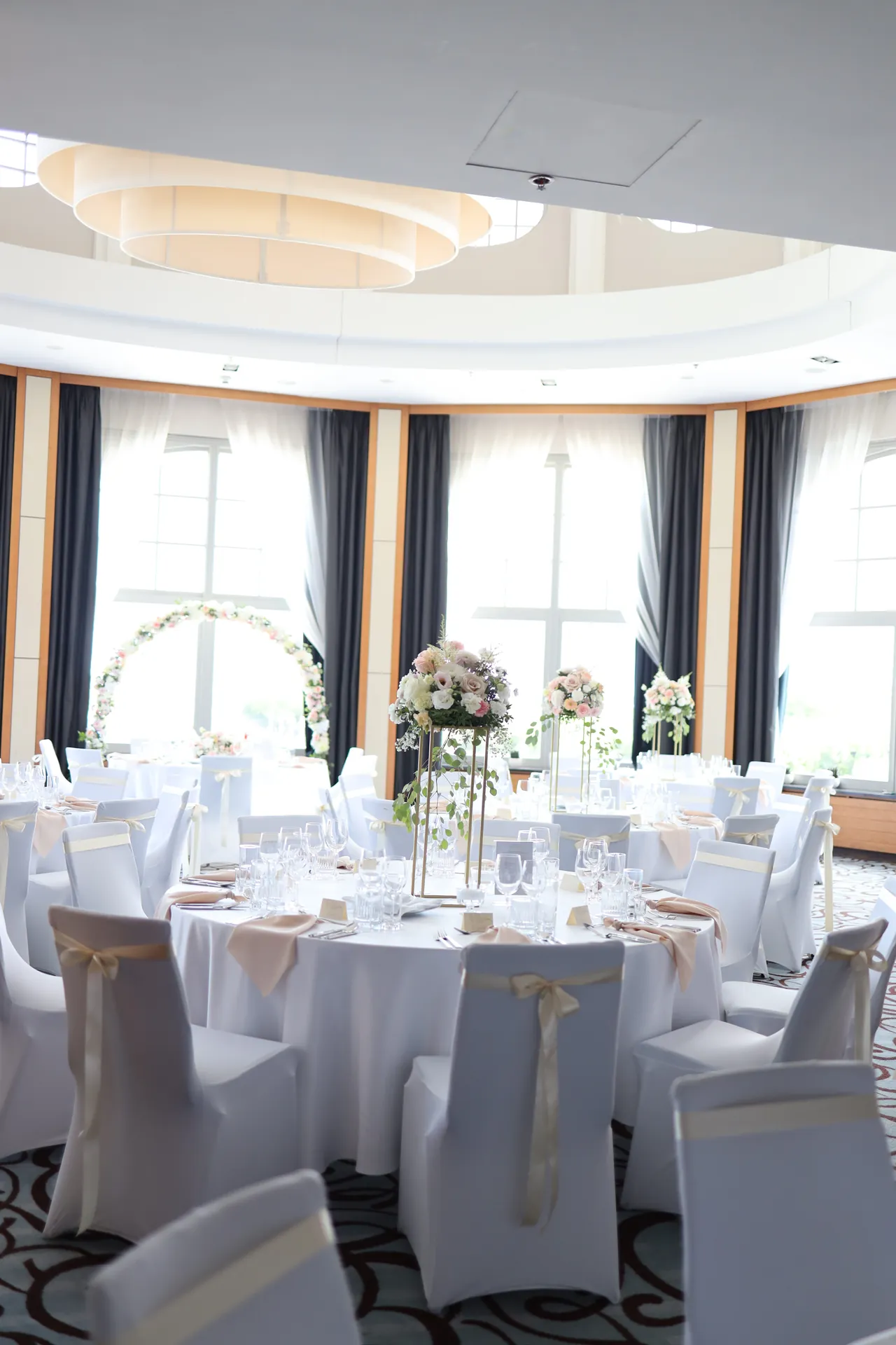 Rotunda Baltic Panorama under the dome with round tables, chairs with white covers and a flower hoop by the window