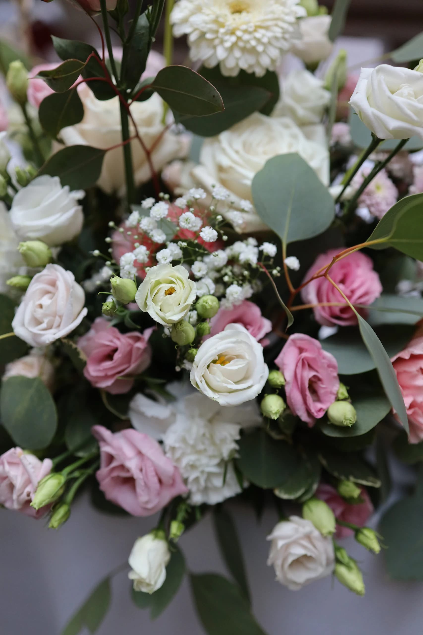 Close-up of flowers: white and pink eustomas, white roses, gypsophila, eucalyptus leaves, white carnation and cream gerbera