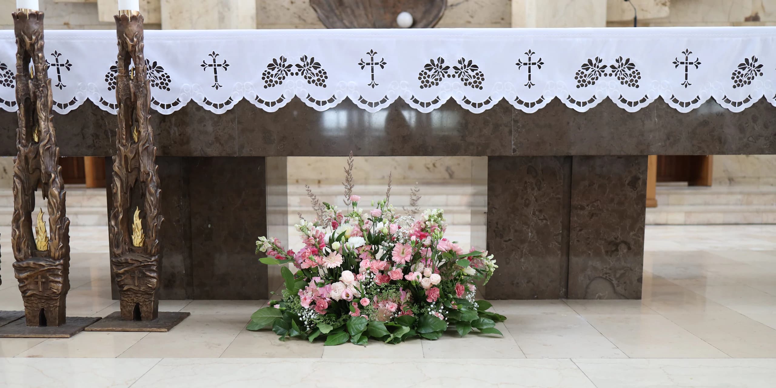 A pink and white composition on the floor at the foot of the altar: snapdragons, gerberas, carnations, eustomas, spray roses, hydrangea and gypsophila